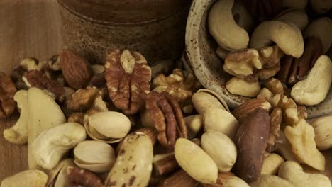 Close-up-macro:-Healthy-mixed-nuts-revolve-on-wooden-board-block