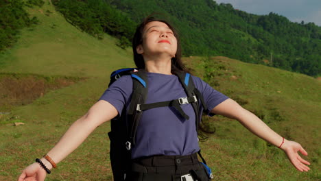 young-asiatic-female-backpackers-breathing-fresh-pure-unpolluted-air-during-a-mountains-trekking-slow-motion