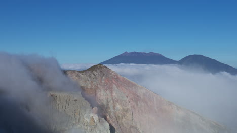 Cliff-of-cloud-pouring-into-the-volcano-creator-at-mount-Ijen,-East-Java,-Indonesia