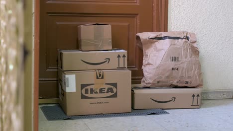 Online-purchases-from-retail-companies,-Amazon-and-Ikea,-as-packages-are-places-in-front-of-a-customer's-door