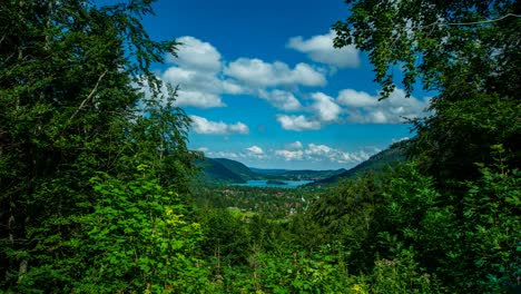 Timelapse-with-schliersee-in-the-background,-surrounded-by-trees-and-passing-clouds