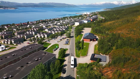 Drone-Siguiendo-El-Autobús-En-Una-Carretera-Panorámica-En-Tromso,-Noruega