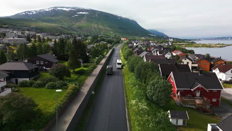 Bus-on-road-in-Tromso,-Norway,-drone-follow-the-vehicle