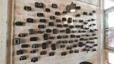 Sammlung-Von-Vintage-Kameras,-Die-An-Einer-Wand-Hängen-Und-In-Einem-Café-In-Thailand-Ausgestellt-Sind