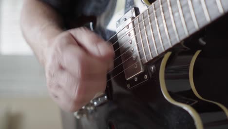 Close-up,-side-view-of-a-guitarist's-right-hand-playing-rhythm-on-an-electric-guitar
