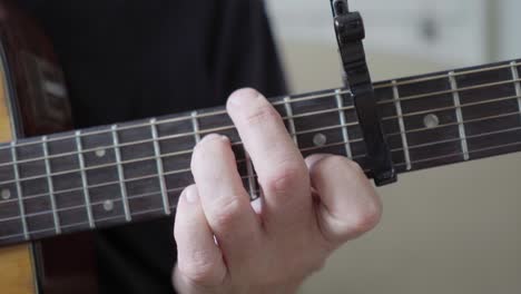 A-guitarist's-left-hand-playing-an-acoustic-steel-string-guitar
