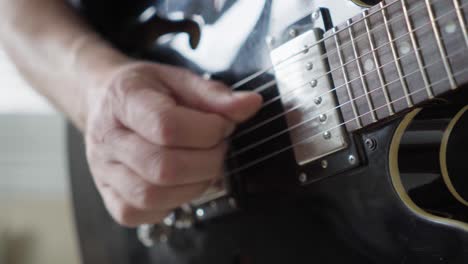 Close-up-of-a-guitarist's-right-hand-playing-fingerstyle-on-an-electric-335-style-guitar