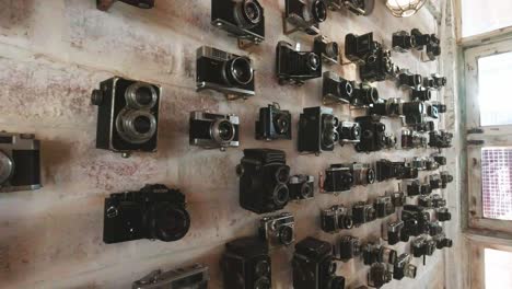 Sammlung-Von-Vintage-Kameras,-Die-An-Einer-Wand-Hängen-Und-In-Einem-Café-In-Thailand-Ausgestellt-Sind