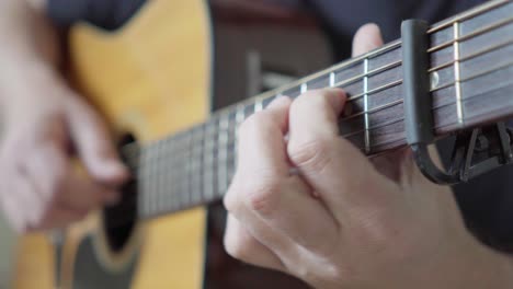 Close-up,-side-view-of-a-guitarist-playing-an-acoustic-steel-string-guitar