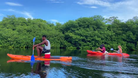 Mother-and-son-rowing-in-a-kayak-guided-by-a-local-Colombian-islander-man-in-tropical-lake