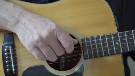 A-guitarist's-right-hand-playing-fingerstyle-on-an-acoustic-steel-string-guitar