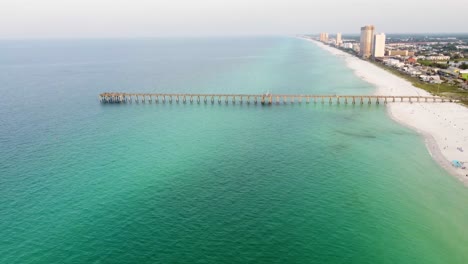 Aerial-of-Panama-City-Beach-Pier-at-Pier-Park-over-the-gulf-of-mexico-turquoise-blue-and-green-water