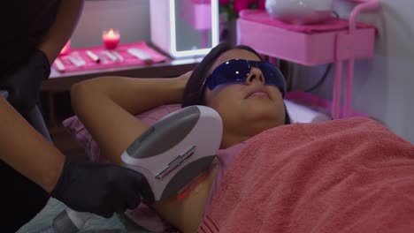 Young-woman-at-a-spa-gets-lazer-hair-removal-treatment-on-her-underarms