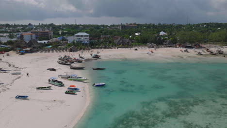 Aerial-view-of-sandy-beach-with-boats-and-people-background,,Kendwa-village,-Zanzibar,-Tanzania