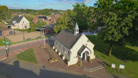 Orbit-drone-shot-of-Cornelius-chapel-in-Brabant-rural-Dutch-village-Gastel
