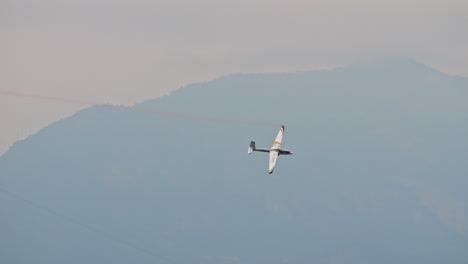 Glider-plane-soaring-in-sky-at-aerobatics-air-show-in-Dolomite-mountains