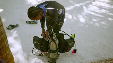 Professional-Scuba-Diver-In-Wetsuit-Preparing-Equipment-For-A-Dive