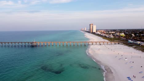 Panama-City-Beach-Pier-Aerial-shot-of-the-silhouette-of-a-fishing-pier-on-the-ocean-with-a-colorful-and-golden-sunrise