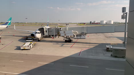 Geparktes-Westjet-Flugzeug,-Verbunden-Mit-Der-Ladebrücke-Am-Flughafen-Gate-Am-Flughafen-Calgary-YYC-Am-18.07.2023