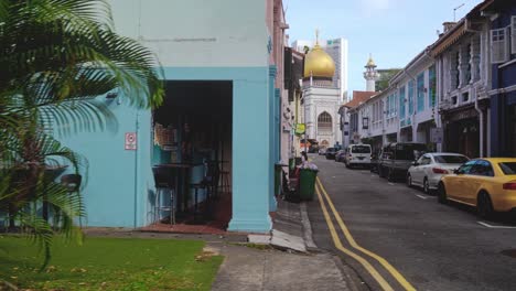 A-walk-across-a-street-with-the-Sultan-Mosque-in-the-background,-Singapore