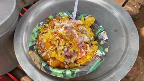 Close-up-shot-of-aloo-tikki-chaat,-a-mouth-watering-Indian-snack-been-served-at-a-roadside-food-stall-at-daytime