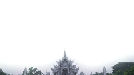 White-sky-above-Chiang-Rai-Wat-Rong-Khun-ornate-white-temple,-Thailand