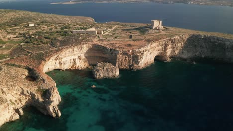 Aerial-drone-footage-over-clear-turquoise-waters-of-Malta's-Blue-Lagoon
