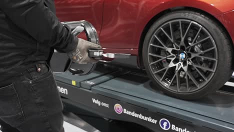 Wheel-balancing-and-alignment-equipment-on-a-car-wheel-at-a-repair-shop,-BMW-M2-luxury-car-wheel-balancing-and-alignment