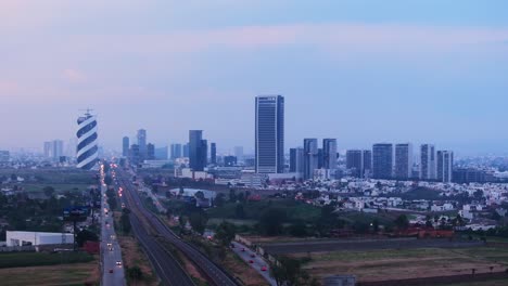 Puebla-Mexico-downtown-city-skyline-at-blue-hour-hazey-dusk,-aerial-rising-establish