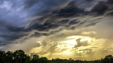Gewitterwolken-Im-Zeitraffer-Mit-Gelben-Sonnenlichtbrechungen,-Geschichtete-Wolken-über-Dem-Wald-Im-Morgengrauen,-Schöner-Anblick,-Wolkenbildung-In-Blau,-Orange,-Dunstiger,-Düsterer-Himmel-Am-Horizont,-Epische-Wolken