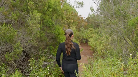 Woman-walking-through-forest,-handheld-dynamic
