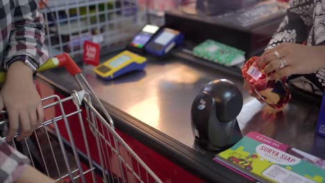 In-Supermarket,-Checkout-Counter-Cashier's-Hands-Scan-Groceries,-household-supplies-and-other-Healthy-Foods