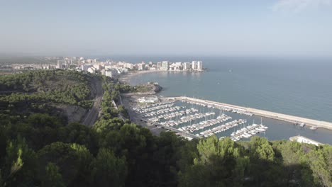 4K-Aerial-view-approaching-Oropesa-del-Mar-sail-sport-port-and-the-scenic-view-of-the-touristic-beach-by-the-Mediterranean-Sea,-Spain