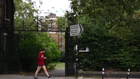 Walking-past-the-Great-Ormond-Street-Hospital,-London,-United-Kingdom