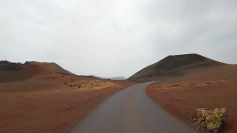 timanfaya,-volcanic-natural-park-of-Lanzarote-driving-on-the-road-point-of-view-from-the-front-of-the-car-lunar-landscape