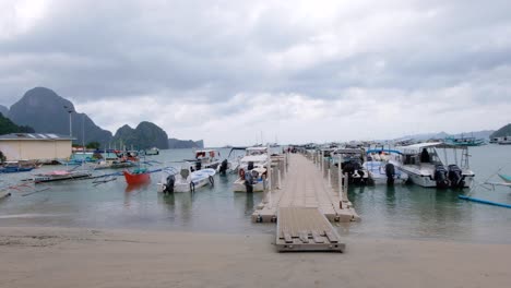 Vista-Panorámica-Del-Tranquilo-Puerto-Con-Barcos-Turísticos-Y-Muelle-Flotante-Para-Populares-Excursiones-De-Isla-En-Isla-En-El-Nido,-Palawan,-Filipinas