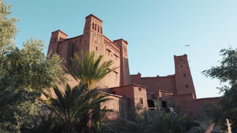 Wide-view-of-traditional-mud-buildings-and-palm-trees-in-Ait-Ben-Haddou,-Morocco