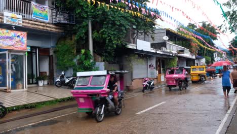 Filipino-tricycle-taxis-and-traffic-on-the-streets-during-Pintados-Kasadyaan-festival-celebration-in-Coron-Town,-Palawan-in-the-Philippines,-Southeast-Asia