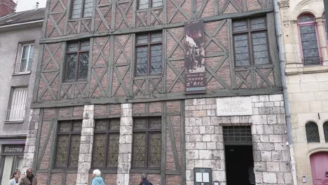 City-Orleans-in-France-on-a-rainy-day-a-museum-House-of-Joan-of-Arc,-half-timbered-building,-with-street-and-pedestrians