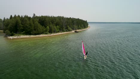 Aerial-view-of-windsurfer-along-shoreline-on-Lake-Huron,-Michigan