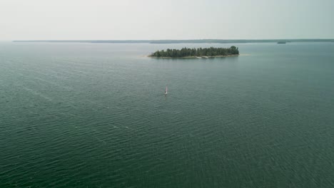 Aerial-view-of-windsurfer-and-small-island-on-Lake-Huron,-Michigan