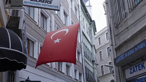 Large-red-Turkish-flag-hanging-between-buildings,-Istanbul
