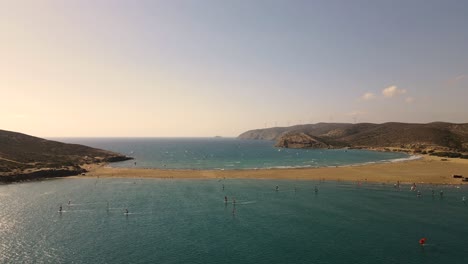 Windsurfer-and-kitesurfer-on-beautiful-Mediterranean-beach-in-Greece,-aerial