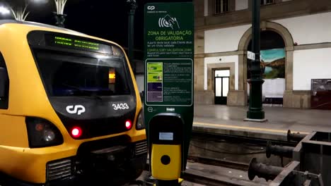 Ticket-scanner-machine-at-Sao-Bento-Station-in-front-of-train,-Porto