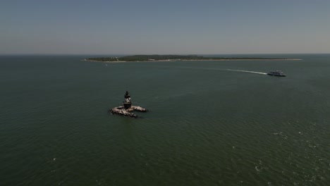 An-aerial-view-of-Long-Island-Sound-with-the-Orient-Point-lighthouse-off-the-east-end-of-Orient-Point,-NY-on-a-sunny-day