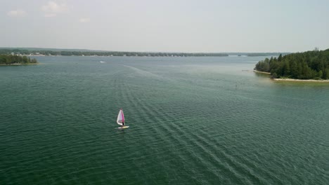 Aerial-view-orbit-of-windsurfer-on-Lake-Huron,-Les-Cheneaux-Islands,-Michigan