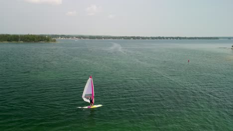 Aerial-follow-of-windsurfer-from-side-on-lake,-Michigan