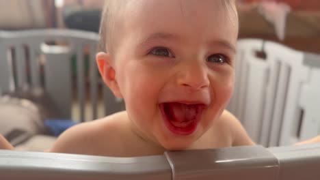 Big-baby-laugh,-with-true-joy-of-happiness,-portrait-of-Caucasian-toddler-standing-in-his-playpen