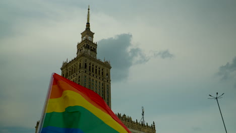 Colorful-LGBT-flag-waving-against-the-backdrop-of-the-Palace-of-Culture-and-Science-in-Warsaw-on-the-main-square-in-the-center-of-the-capital