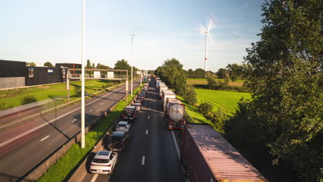 Traffic-jam-and-windmill-on-sunny-day-in-Belgium-highway,-time-lapse